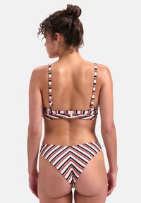 Set di bikini a righe con spalline regolabili, chiusura a gancio e un motivo a zigzag sui pantaloni in colori rosso, bianco e blu navy.