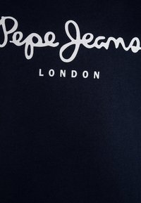 T-paita tummansinisestä puuvillasta, jossa rintaosassa on valkoiset ''Pepe Jeans LONDON'' -tekstit kauniilla käsinkirjoitustyylillä. Sileä, yksinkertainen pinta.