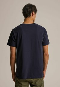 Granatowa koszulka z krótkim rękawem i okrągłym dekoltem, wykonana z miękkiego materiału, o gładkim wzorze bez widocznych logo lub wzorów.