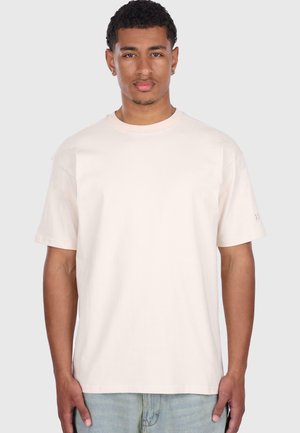 Light beige cotton T-shirt with a crew neckline, short sleeves, and a relaxed fit. Subtle branding on the left sleeve.