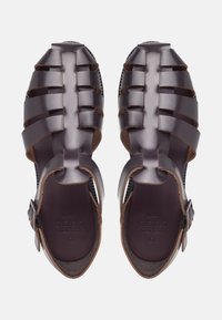 Dunkelbraune Kunststoffsandalen mit einem Riemendesign, ausgestattet mit einer verstellbaren Schnalle, strukturiertem Fußbett und offener Zehenkonstruktion.