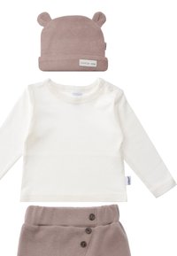 Das Set umfasst ein cremefarbenes Langarmshirt, eine staubig rosa gerippte Mütze mit Bärenohren und passende gerippte Hosen mit drei Knöpfen auf der Vorderseite.