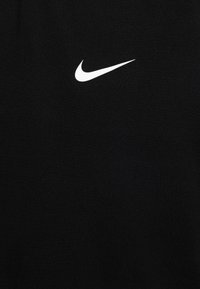Čierne športové tričko vyrobené z hladkej tkaniny, s bielym logom Nike na hrudi. Jednoduchý dizajn, bez ďalších vzorov alebo akcentov.