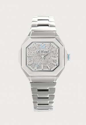 Montre-bracelet en métal argenté avec un cadran octogonal, un cadran orné de cristaux, un affichage de la date et un logo "Off-White" sur le cadran.