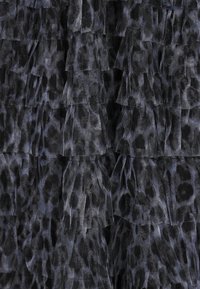 Sort og grå rynket stof med et leopardmønster. Texturen er lagdelt med gennemsigtige sektioner, hvilket skaber dybde og bevægelse.