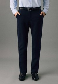 Námornícke nohavice z hladkej tkaniny, s rovným strihom, bočnými vreckami a čiernym opaskom, ktorý zvýrazňuje pás.