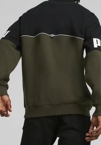 Sudadera Puma con la parte superior negra y la mitad inferior de color verde olivo. Diseño sólido con acentos en blanco en las costuras y el logo.