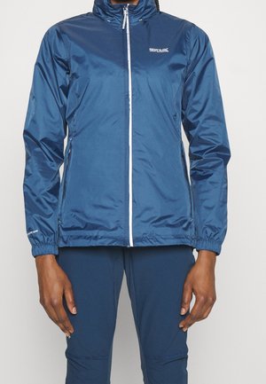 Veste légère bleue zippée avec col montant et poignets élastiques portée avec un pantalon assorti, arborant le logo "Regatta Great Outdoors".