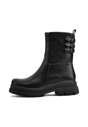 Stivali alla caviglia in pelle nera con punta arrotondata, suola spessa e tre fibbie decorative sul lato. Texture liscia e design elegante.