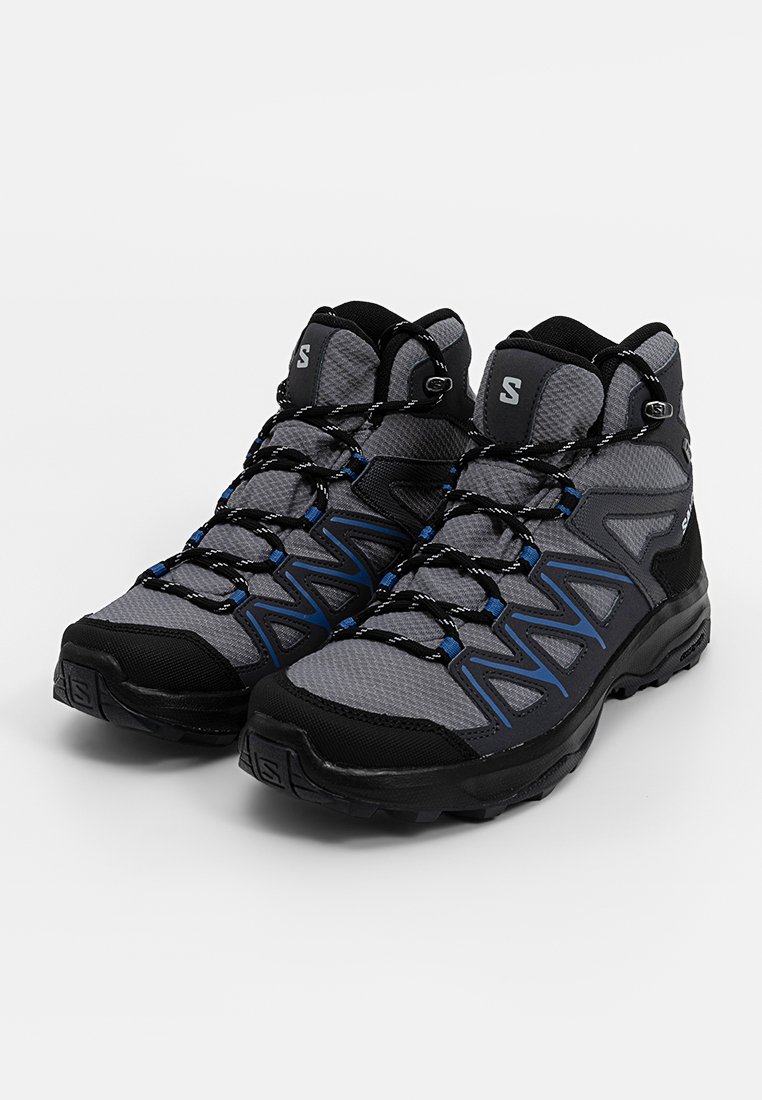 Półwysokie buty trekkingowe wykonane z szarej siateczki i czarnej gumy, z niebieskimi akcentami, wzmocnionym noskiem oraz zabezpieczonym systemem sznurowania.