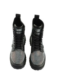 Botas de combate negras con un upper adornado con brillantes de strass, una superficie texturizada y una suela de goma negra gruesa.