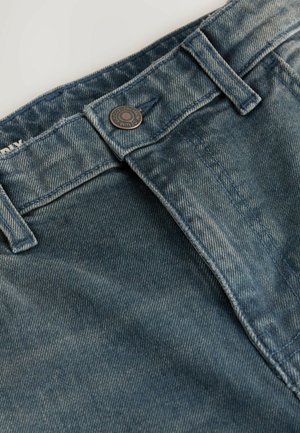 Denim-Jeans in einem verblassten blauen Waschgang, ausgestattet mit einem Metallknopfverschluss, klassischen Taschen und kontrastierenden Nähten entlang der Säume.