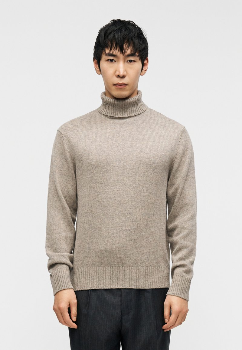 Μπεζ πουλόβερ με ζιβάγκο, με ριμπ λαιμόκοψη και μανσέτες, κατασκευασμένο από πλεκτό υλικό, με χαλαρή εφαρμογή και λεία υφή.