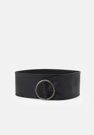 Szeroki czarny skórzany pasek z dużą srebrną okrągłą klamrą na białym tle.