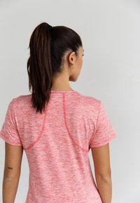 Roze, gemêleerd, sportief T-shirt met korte mouwen en raglannaden, met een gladde textuur en een ontspannen pasvorm, gezien van achteren.