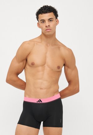 Schwarze Boxershorts aus glattem Stoff mit einem pinkfarbenen elastischen Bund, der ein Logo und Kontrastnähte aufweist.