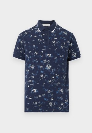 Polo de manga corta color azul marino con un patrón abstracto de hojas en blanco y azul claro, tapeta de tres botones y ribete blanco en el cuello y las mangas.