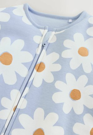 Pagliaccetto in cotone azzurro chiaro con grandi margherite bianche e centri arancioni. Presenta una chiusura frontale con zip e un colletto a costine.
