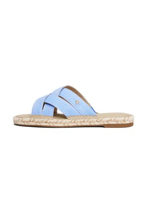 Lyseblå stof slip-on sandal med krydsede remme, flettet jutesål og lille metallisk logo på en rem, flad hæl.