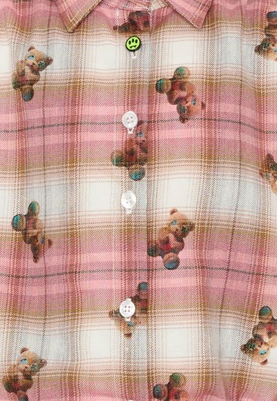 Camicia a quadri rosa con stampe di orsetti; realizzata in tessuto leggero con una texture morbida. Bottoni bianchi e dettaglio di una spilla verde con faccina sorridente.