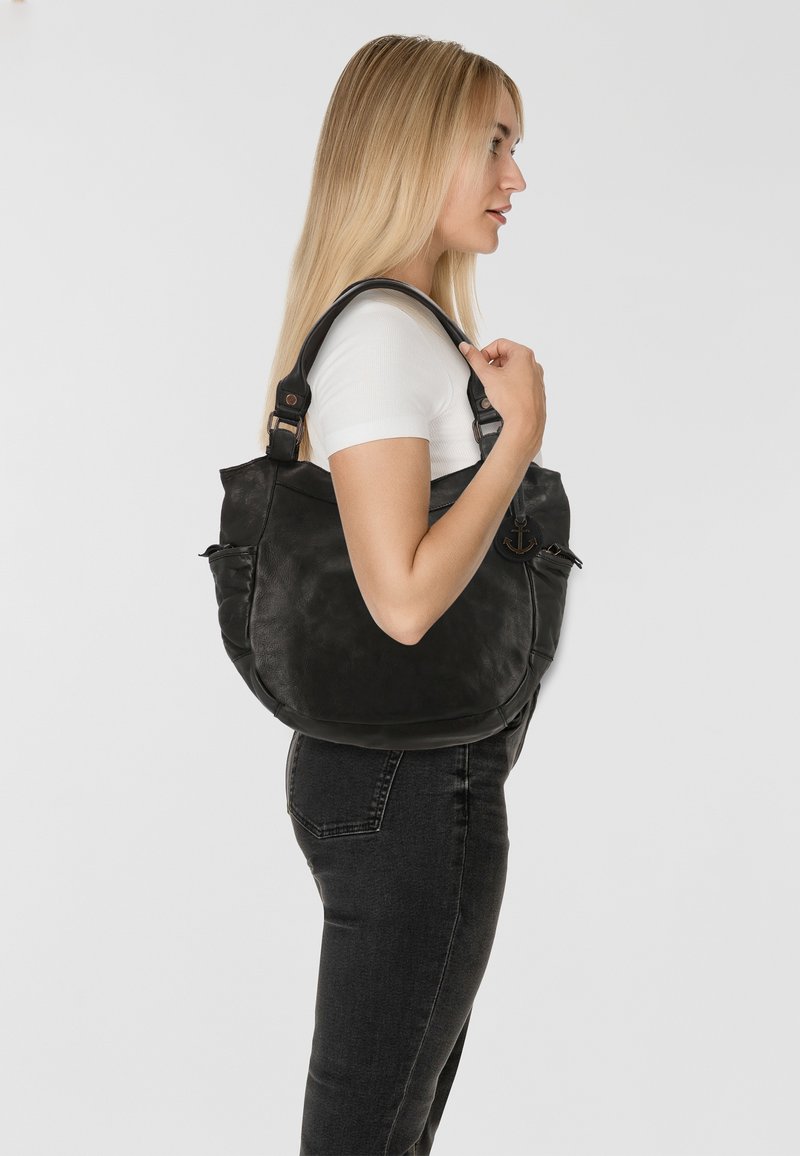 Borsa a spalla in pelle nera con forma curva, dotata di una tasca frontale e di un logo ancore in evidenza. La tracolla è regolabile e robusta.