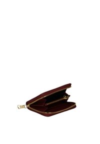Portafoglio bordeaux realizzato in materiale testurizzato con zip dorata. Due scomparti interni per carte e contanti, con tasca con zip.
