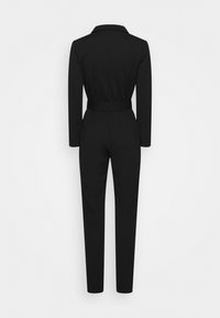 Combinaison noire à manches longues, taille ceinturée et jambes ajustées. Fabriquée en tissu doux, avec un col et un design épuré au dos.