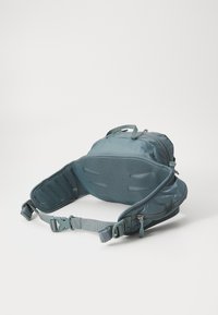 Zaino turchese con un'esterno morbido e strutturato, dotato di un pannello posteriore in rete e di spallacci regolabili. Tasca con zip sul lato per riporre oggetti.