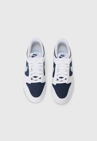 Nike-skor med en marinblå ovandel, vita accenter och perforerade detaljer. Har vita snörning och en ljusblå logotyp på innersulan.