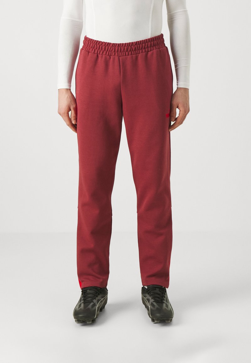 Rote Jogginghose mit elastischem Bund, schlanker Schnitt, weichem Material und dezentem Markenlogo in Rot am linken Oberschenkel.