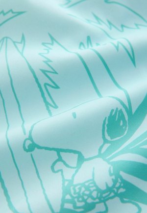 Lichtblauwe stof met een groot bedrukt ontwerp van Snoopy temidden van abstracte vormen en lijnen, wat een soepele textiele textuur creëert.