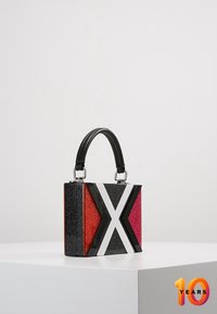 Borsa quadrata con manico nero, con pannelli scintillanti rossi, rosa e neri e un design prominente a striscia diagonale bianca.