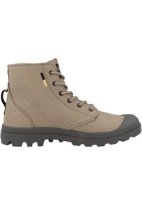 Stivali realizzati in morbido pelle beige chiaro con una punta in gomma grigia, suola robusta e design con lacci. Presenta una linguetta sul retro.
