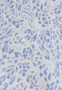 Leichter Stoff in Weiß mit einem Blumenmuster in verschiedenen Blautönen. Die Textur ist weich und leicht flauschig, was das Design betont.