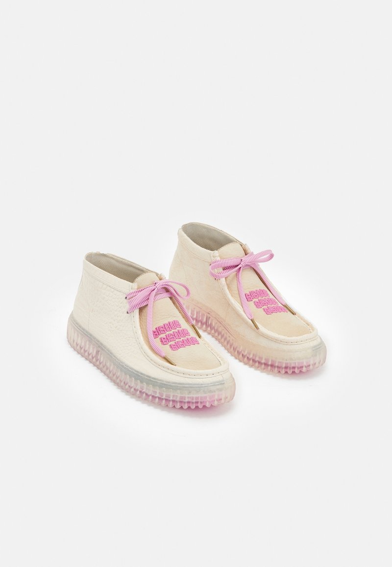 Chaussures couleur crème avec une tige texturée, des lacets roses et une semelle translucide présentant un dégradé du transparent au rose. Détails avec logo en accents.