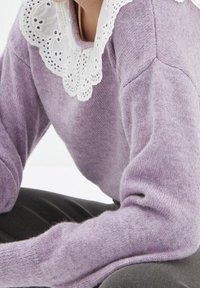 Maglione a maglia lilla con finitura testurizzata, dotato di un colletto in pizzo bianco con intagli intricati e scollatura rotonda.