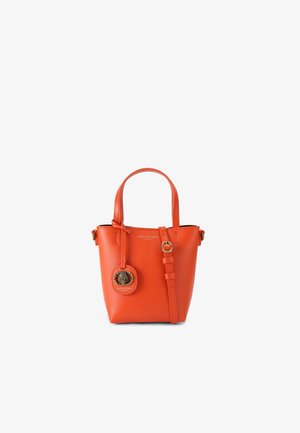 Piccola borsa a tracolla in pelle arancione con un charm rotondo, tracolla regolabile e manici corti. Texture liscia e design minimalista.