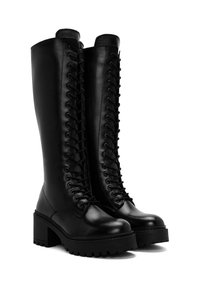 Botas altas de cuero negro con tacón grueso, que presentan un cordón frontal y suela de goma texturizada para agarre y estabilidad.