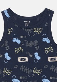 Temno modra brezrokavnik s svetlo rumenim in modrim vzorcem igralnih kontrolerjev, tipkovnic, prenosnih konzol in igralnih tipk.