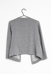 Grå långärmad tröja med rundad halsringning, hög-låg fåll och sidofickor. Tillverkad av ett mjukt, lättviktsmaterial. Visas på en svart galge.