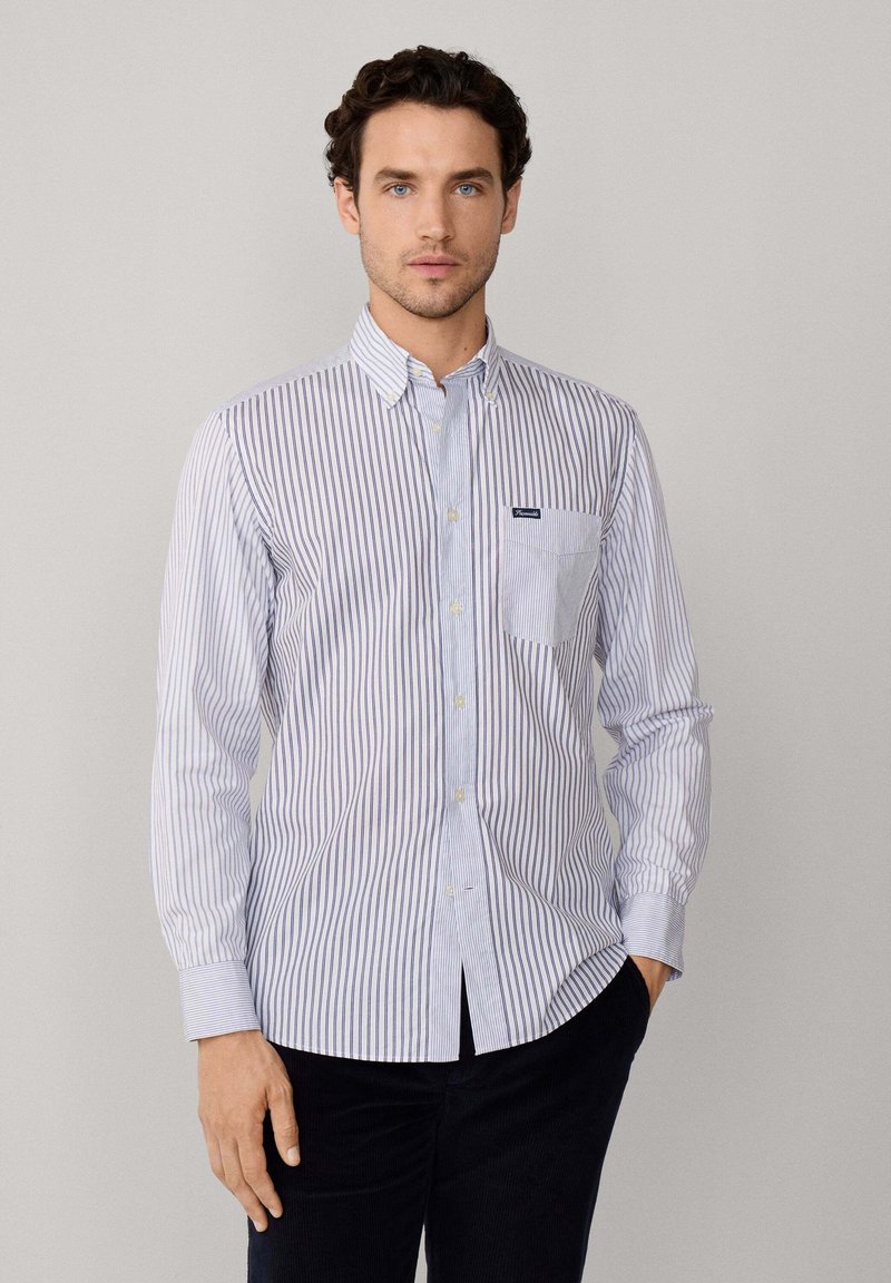 Camicia a righe button-down in azzurro chiaro e bianco, con taschino sul petto e maniche lunghe con polsini bottonati. Il tessuto ha una finitura liscia.