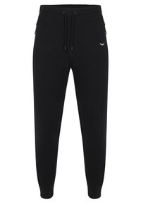 Pantalon de survêtement noir fuselé avec taille élastique, cordon de serrage, poches latérales zippées, empiècements aux genoux et petit logo blanc sur la cuisse droite.