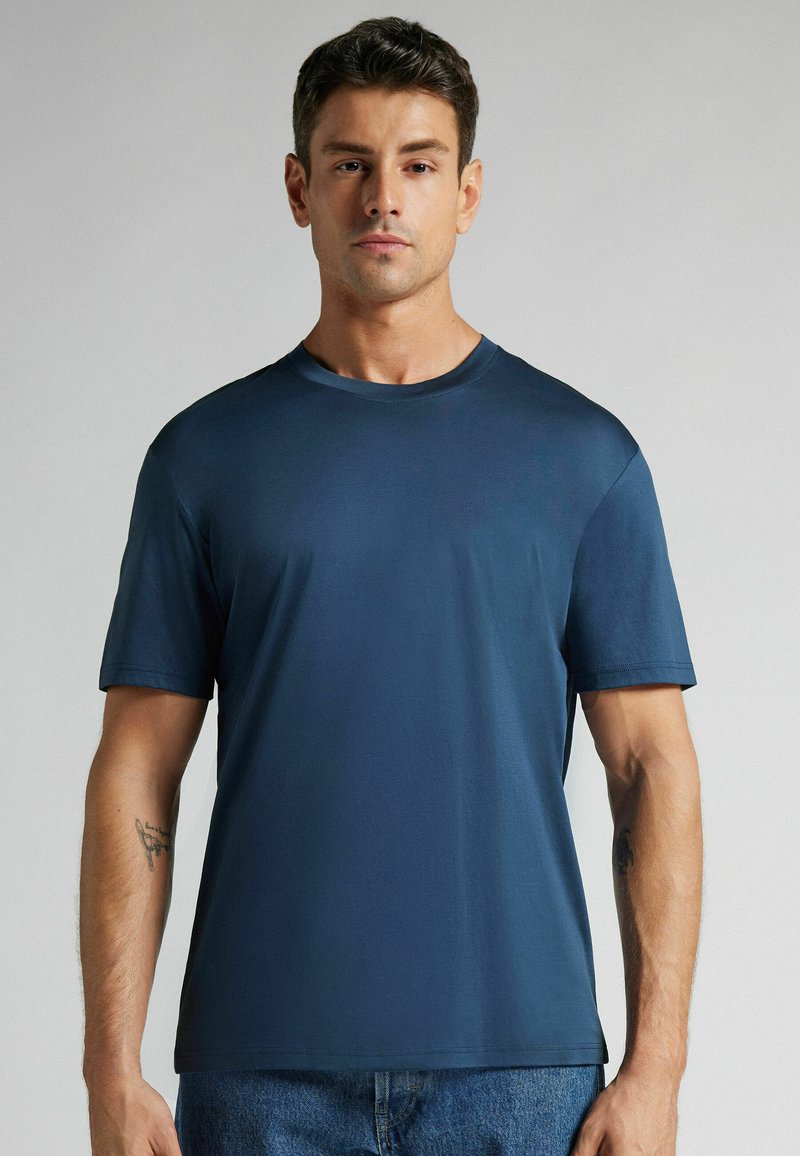 T-shirt à manches courtes bleu marine en tissu lisse avec un col rond, présentant une coupe décontractée et sans motifs ni accents visibles.