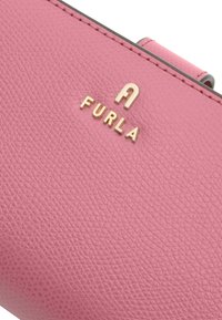 Roze leren portemonnee met een gestructureerde afwerking, voorzien van een gouden "FURLA" logo en een gladde, metallic sluiting.