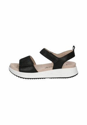 Sandale noire avec tige texturée, sangle ajustable et semelle blanche rembourrée. Caractérisée par un léger talon et une semelle en caoutchouc noire à motif.