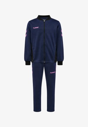 Marineblauw trainingspak met rits en roze hummel-logo's op borst, been en mouw, met zwarte kraag en manchetten en zijzakken.