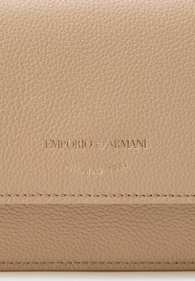 Μπεζ δερμάτινο πορτοφόλι με υφή στην επιφάνεια. Διαθέτει ανάγλυφο λογότυπο "Emporio Armani" και τη φράση "Milano 1981" στο κάτω μέρος.