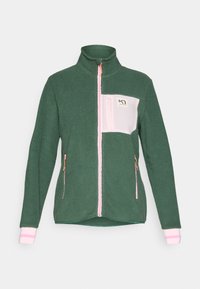 Grønn fleecejakke med høy krage, rosa glidelås, brystlomme i rosa og hvitt, og stripete mansjetter. Strukturert stoff med glidelåslommer på siden.