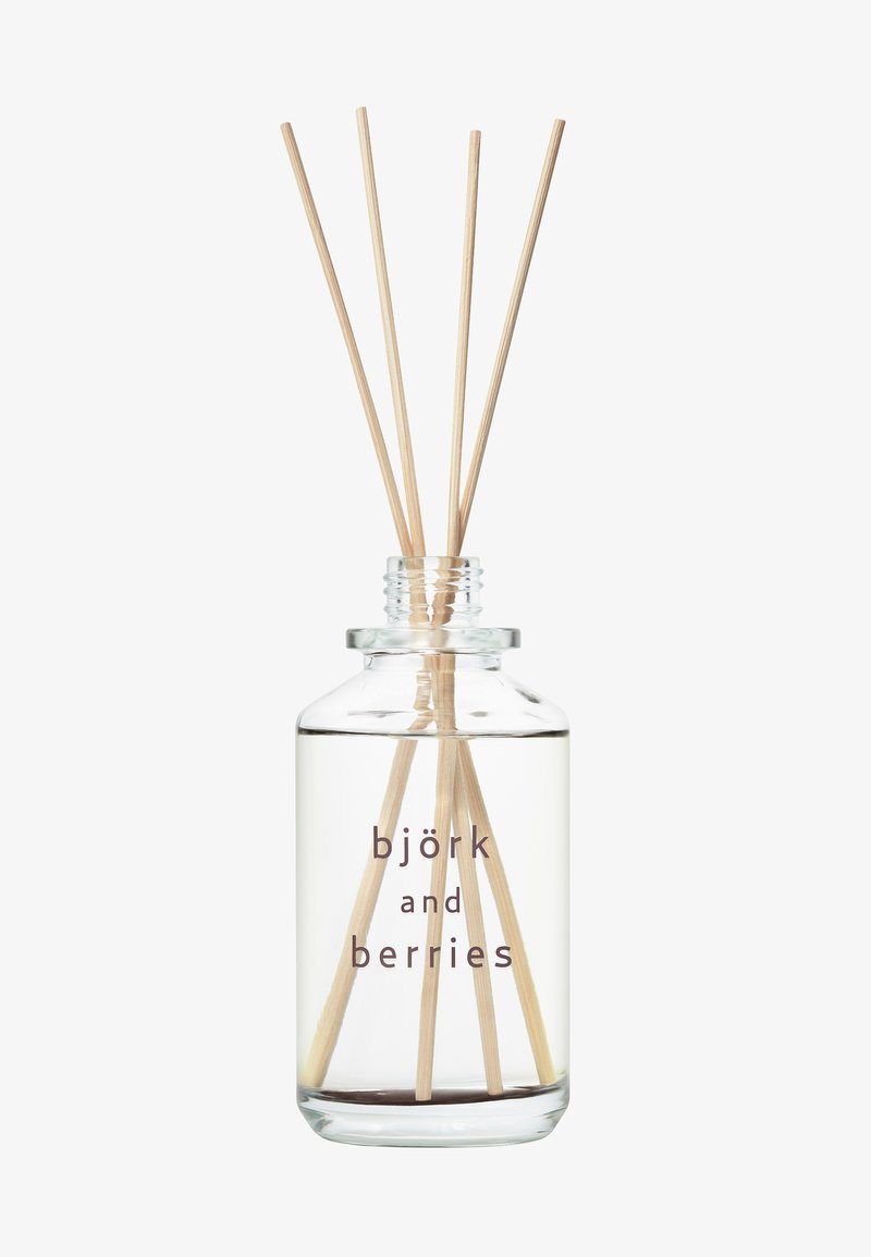 Raumd diffuser in einer klaren Glasflasche mit runder Basis, die eine helle Flüssigkeit und fünf Holzstäbchen enthält, beschriftet mit "björk and berries".