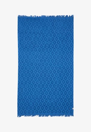 Blauer Textilstoff mit sich wiederholendem geometrischem Muster und fransierten Kanten, vermutlich ein gewebter Schal oder ein Tuch.